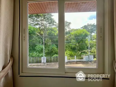 Serene window view of lush greenery from a cozy interior space