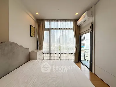 Modern bedroom with large window and city view, featuring air conditioning and elegant decor.