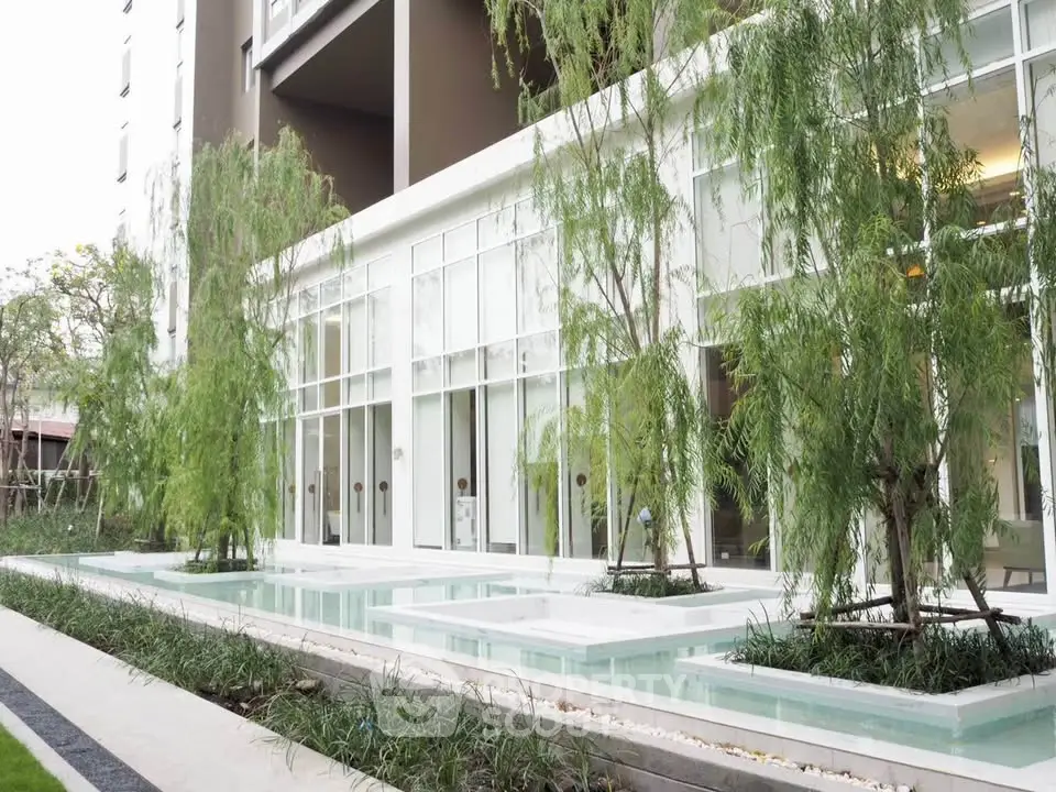 Modern apartment building with elegant water feature and lush greenery
