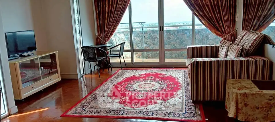 Charming living room with balcony view, elegant rug, and cozy seating area.