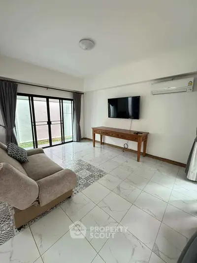 Spacious living room with modern decor and large window for natural light.