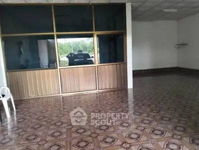 Spacious interior with patterned tile flooring and large glass partition, ideal for versatile use.