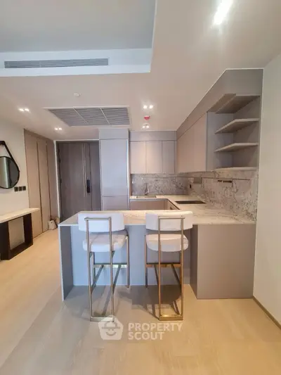 Modern kitchen with sleek design and breakfast bar seating in luxury apartment.