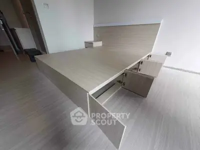 Modern minimalist bedroom with built-in storage bed and sleek wooden flooring.