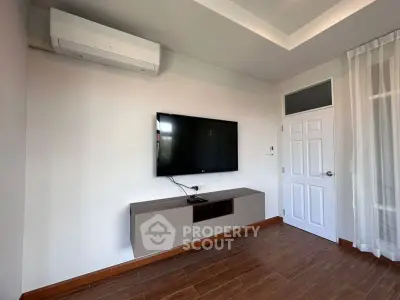 Modern living room with wall-mounted TV and sleek air conditioning unit.