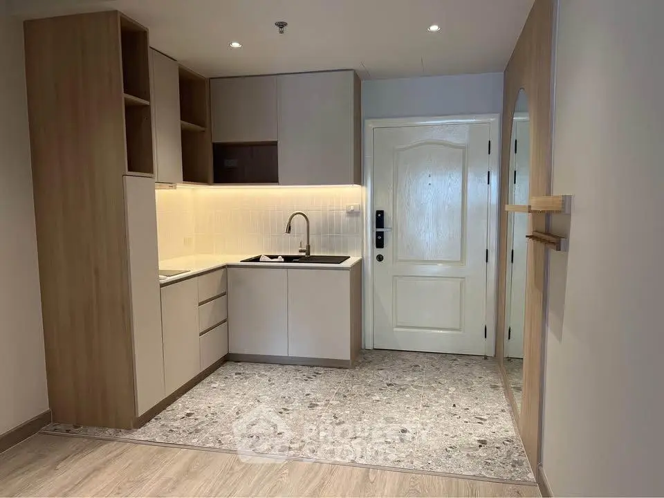 Modern kitchen with sleek cabinetry and stylish lighting in a cozy apartment.