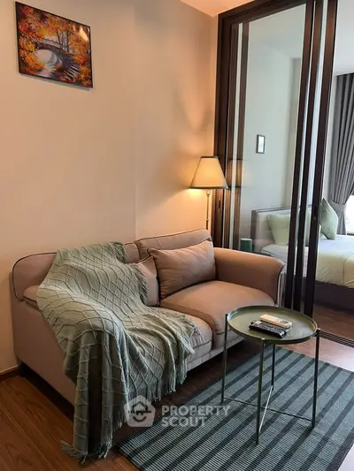 Cozy living room with modern decor and a glimpse into a stylish bedroom.