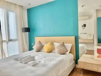 Bright and cozy bedroom with modern decor and large window for natural light.