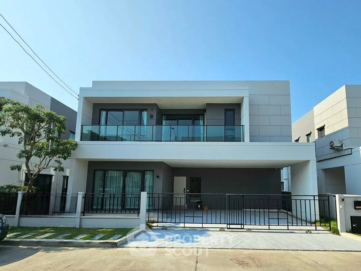 Modern two-story house with sleek design and spacious balcony in a serene neighborhood.