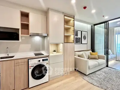 Modern open-plan living room with built-in washer and cozy seating area.