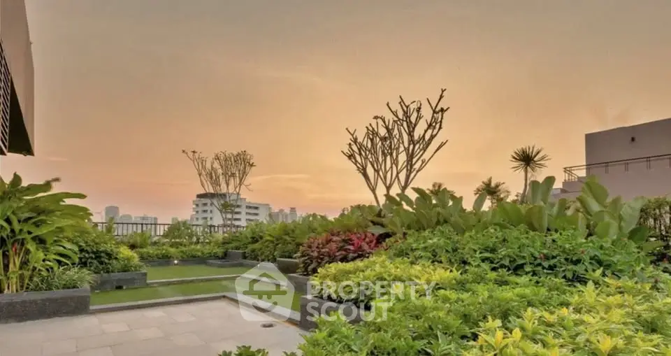 Stunning rooftop garden with lush greenery and city skyline views at sunset.
