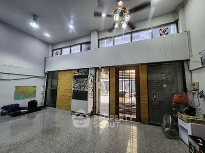 Spacious interior with high ceilings and large windows, ideal for versatile use.