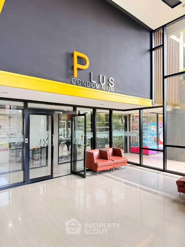 Modern condominium entrance with sleek glass doors and stylish seating area.