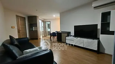 Modern living room with sleek furniture and large TV in a stylish apartment.