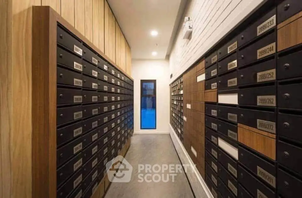 Modern apartment building mailroom with sleek wooden and metal mailboxes.