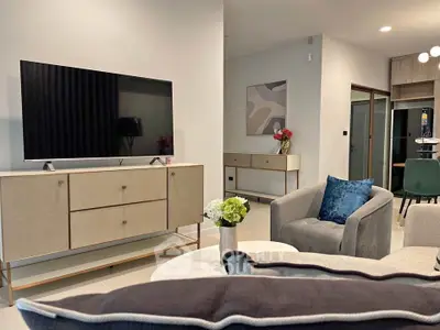 Modern living room with stylish furniture and large TV, perfect for relaxation.