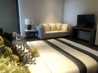 Modern bedroom with cozy seating area and stylish decor