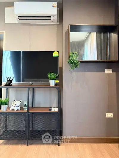 Modern living room with sleek TV stand, air conditioning, and stylish decor accents.