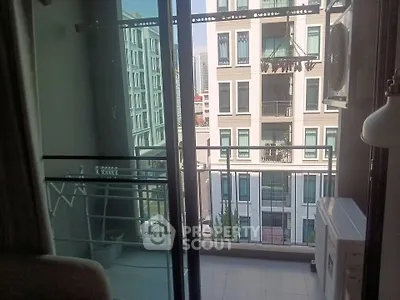 Modern apartment balcony with glass railing and city view, perfect for urban living.