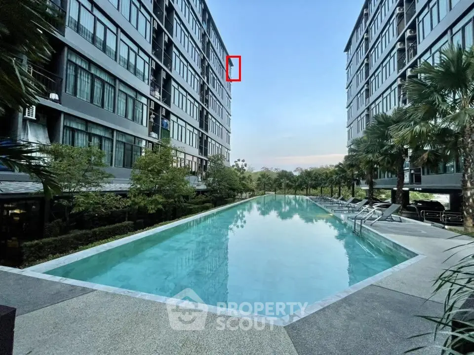 Luxurious apartment complex with serene pool and lush greenery