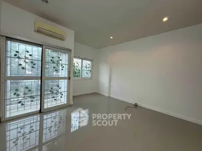 Spacious unfurnished room with large windows and air conditioning, perfect for customization.