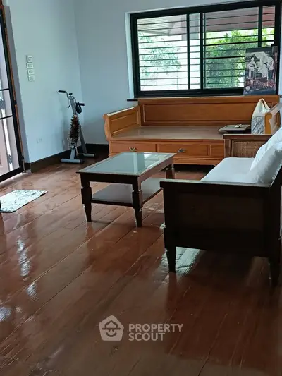 Charming living room with wooden floors and cozy furniture, perfect for relaxation and family gatherings.