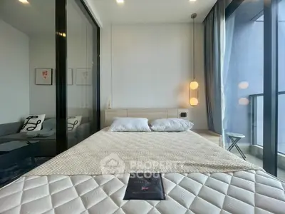 Modern bedroom with large windows and balcony access in a stylish apartment.