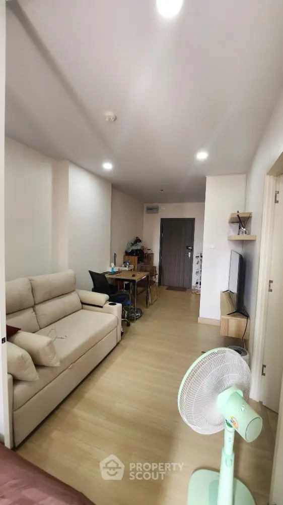 Modern living room with cozy sofa and flat-screen TV, perfect for relaxation and entertainment.