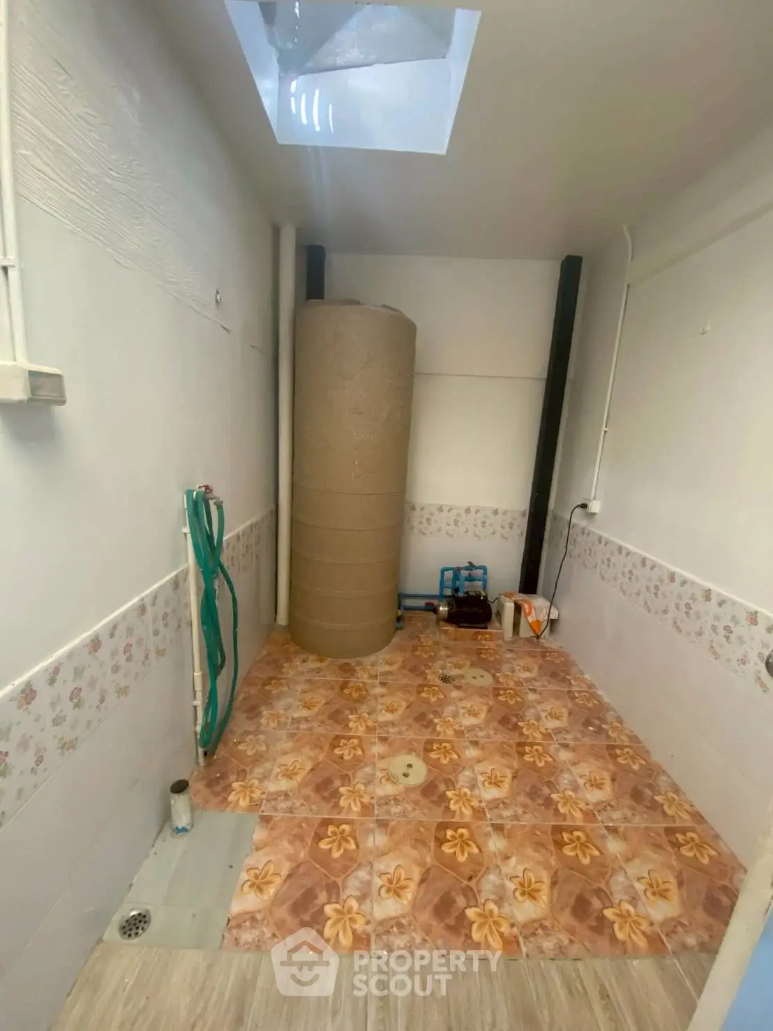 Utility room with tiled floor and water tank, ideal for storage or laundry setup.