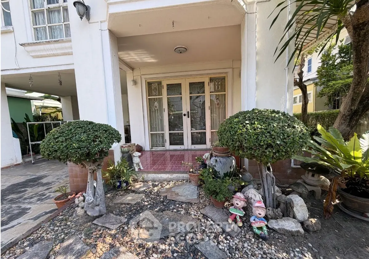 Charming house entrance with decorative plants and stone pathway