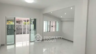 Spacious modern living room with large windows and marble flooring