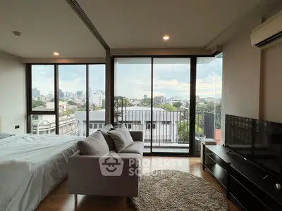 Modern bedroom with city view and balcony access, featuring sleek furniture and large windows.