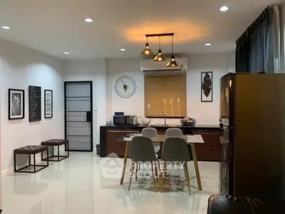 Spacious modern kitchen with sleek countertops, stylish pendant lighting, and a cozy dining area, perfect for culinary enthusiasts and entertaining guests.