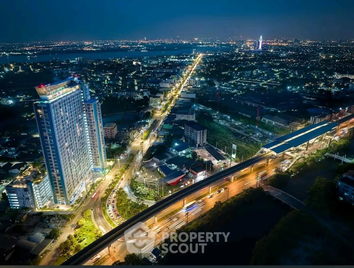 Stunning aerial night view of a vibrant cityscape with illuminated high-rise buildings and bustling streets.