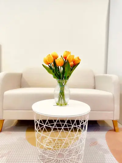Chic living room with modern white sofa and stylish coffee table featuring vibrant tulips.