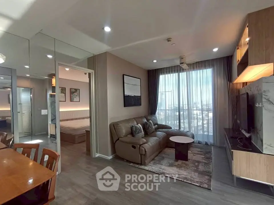 Modern living room with stylish decor and large windows offering city views