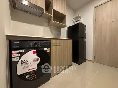 Modern kitchen with washing machine and fridge in compact layout