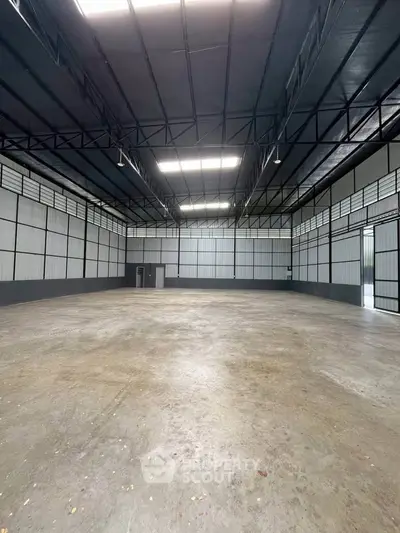 Spacious industrial warehouse with high ceilings and ample natural light.