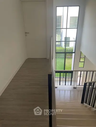Modern staircase with large windows and garden view in a contemporary home