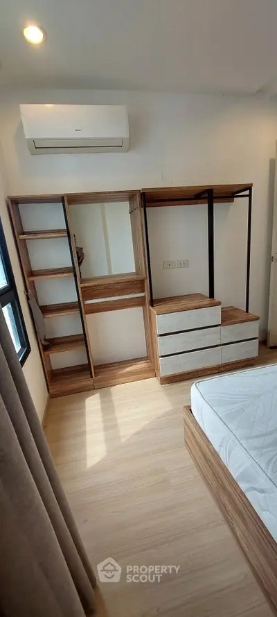 Modern bedroom with built-in wooden wardrobe and air conditioning unit