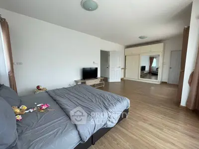 Spacious bedroom with modern decor and large mirror wardrobe
