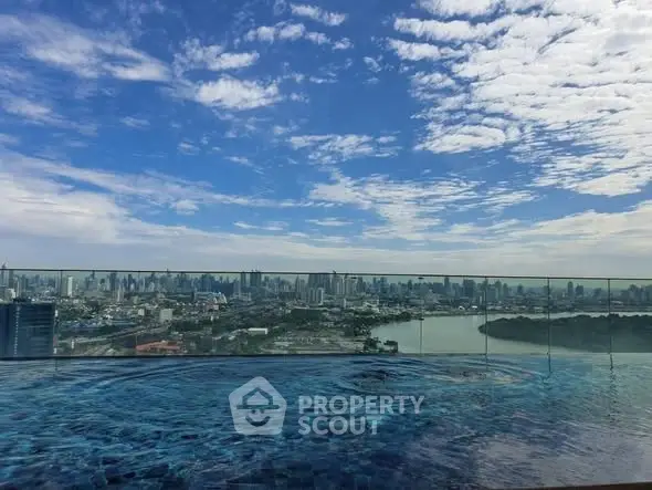 Stunning rooftop pool with panoramic city skyline view under a vibrant blue sky.