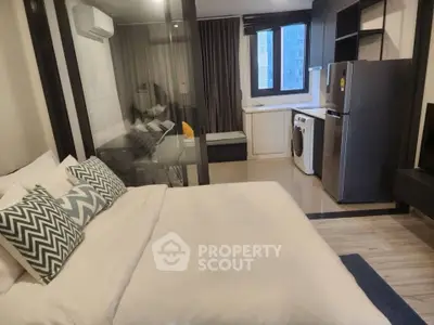 Modern studio apartment with open layout, featuring a cozy bedroom, sleek kitchen, and in-unit laundry.