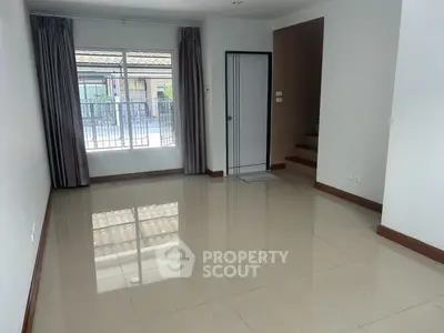 Spacious and well-lit living room with glossy tiled flooring, large windows draped in elegant curtains, and a neutral color palette ready for personalization.