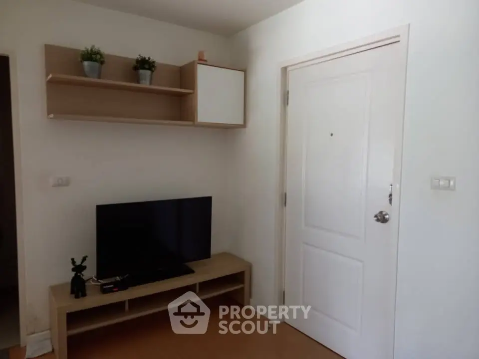 Cozy living room with modern TV stand and wall-mounted shelves, perfect for minimalist decor.