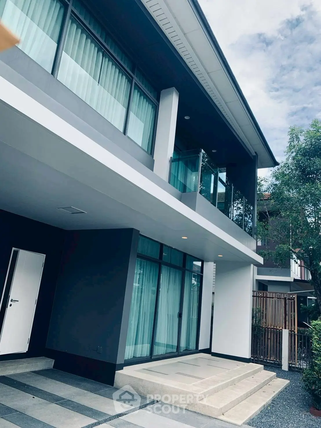 Modern two-story house with large windows and sleek design