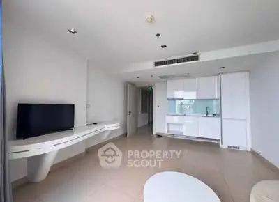 Modern minimalist living room with sleek white cabinetry and wall-mounted TV
