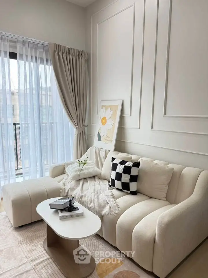 Elegant living room with modern sofa, chic decor, and large window for natural light.