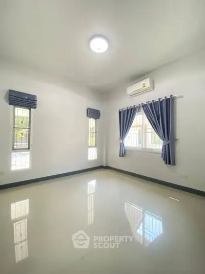 Bright empty room with large windows and air conditioning, perfect for customization.