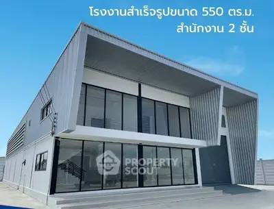 Modern industrial building with sleek design and large glass windows, ideal for office space.